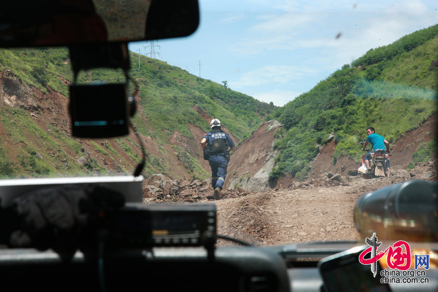 王刚“前出探路”，在塌方区给汽车开道，观察山体的状况，指挥车辆。