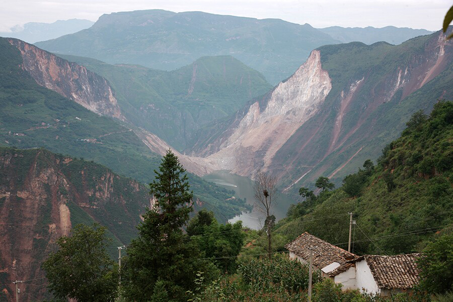 牛栏江边的两座山体崩塌，封住了河水，连日的暴雨让水位快速上涨，淹没了附近的村子。