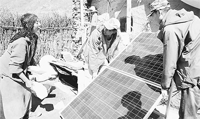 近日，国电集团所属国电电力青海新能源公司“果洛无电藏区独立光伏项目”开始实施。图为施工人员为藏族妇女穷群玛家安装太阳能光伏发电系统。