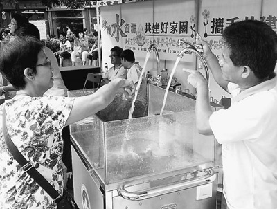 工作人员向市民介绍节水器具。记者　苏宁摄