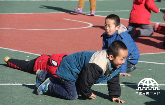 延川县北关小学的学生们在塑胶操场上做游戏。中国网/中国发展门户网 魏博 摄
