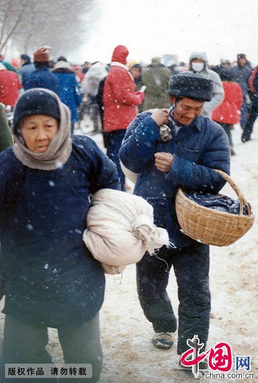  1988年，山东青岛，赶年集的市民。赶年集最为红火，年集上的商品，都是人们过年的必备品。到年集上吃上一次过年才有的小吃是众多孩子的新年愿望，到年集上剃个过年头是很多老人的传统习惯。赵国富 摄 