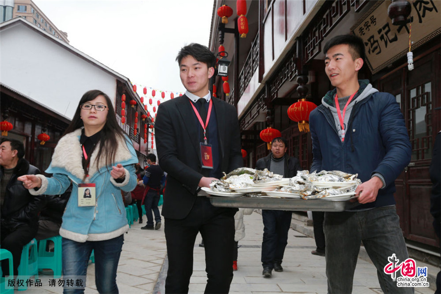 2月7日，贵州安顺好吃一条街开业，商家为食客们上特色小吃。中国网图片库 卢维/摄