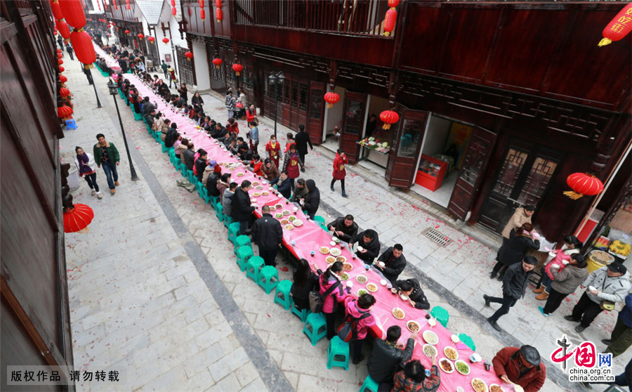 2月7日，食客在贵州安顺好吃一条街上品尝“千人长桌宴”。中国网图片库 卢维/摄