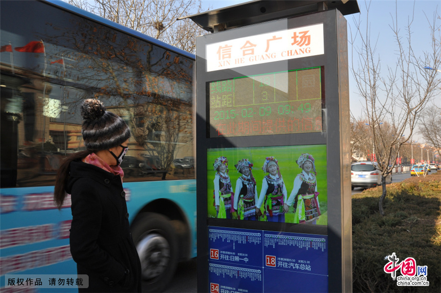 2015年2月9日，在山东省日照市海曲路一公交车站，市民在查看智能公交电子站牌。近日，山东省日照市首批5个智能公交电子站牌在海曲路上亮相。这种新型智能电子公交站牌，具有车辆定位显示、天气预报、公益信息发布等功能，同时还可以通过无线4G网络，进行远程维护。市民在乘坐公交车时，公交车到哪里了一看便知，极大的方便了市民出行。中国网图片库 刘明照/摄