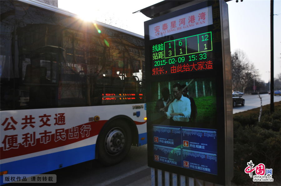 2015年2月9日，在山东省日照市海曲路一公交车站，市民在查看智能公交电子站牌。近日，山东省日照市首批5个智能公交电子站牌在海曲路上亮相。这种新型智能电子公交站牌，具有车辆定位显示、天气预报、公益信息发布等功能，同时还可以通过无线4G网络，进行远程维护。市民在乘坐公交车时，公交车到哪里了一看便知，极大的方便了市民出行。中国网图片库 刘明照/摄