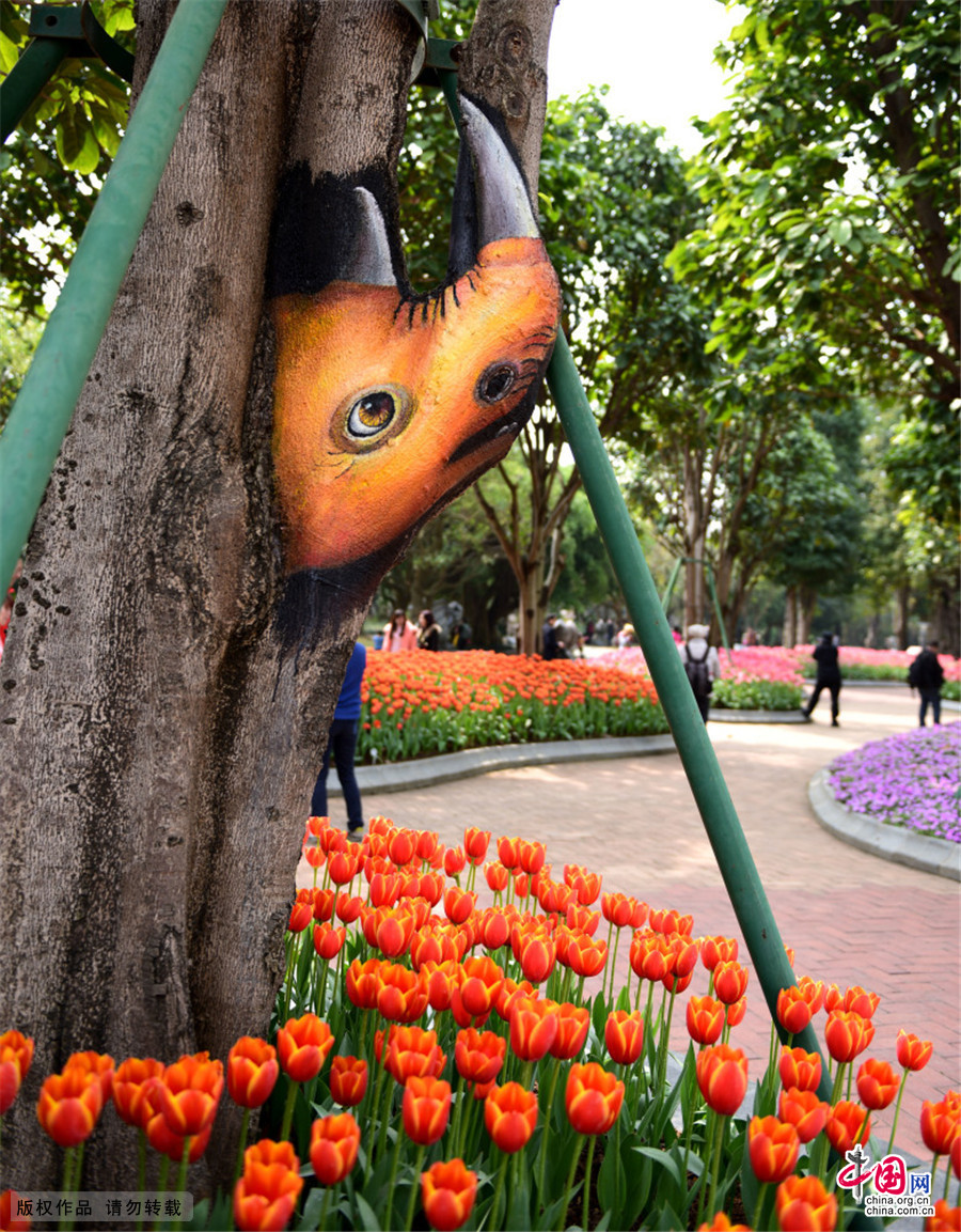 2015年2月8日，广西南宁市青秀山公园郁金香花展吸引众多游客，公园管理方在花展周围的树上，依树的形状，结巴，树枝等绘画出动物绘画，惟妙惟肖惹人爱。中国网图片库 彭寰/摄