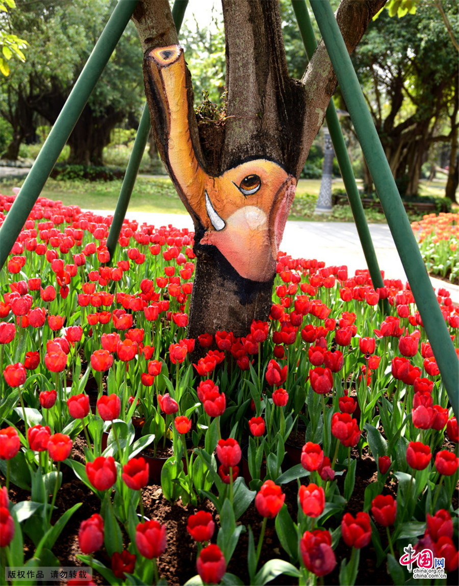 2015年2月8日，广西南宁市青秀山公园郁金香花展吸引众多游客，公园管理方在花展周围的树上，依树的形状，结巴，树枝等绘画出动物绘画，惟妙惟肖惹人爱。中国网图片库 彭寰/摄