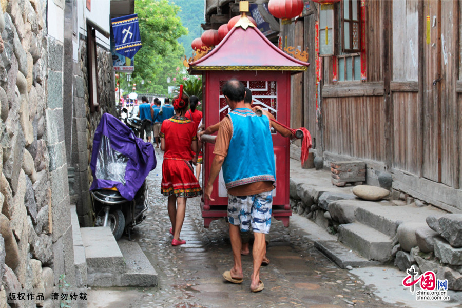 男方派出浩浩荡荡的迎亲队伍，挑着猪肉、米糕、家酒等礼品，)，抬着轿子，到女方家迎亲。中国网图片库 陈士平/摄