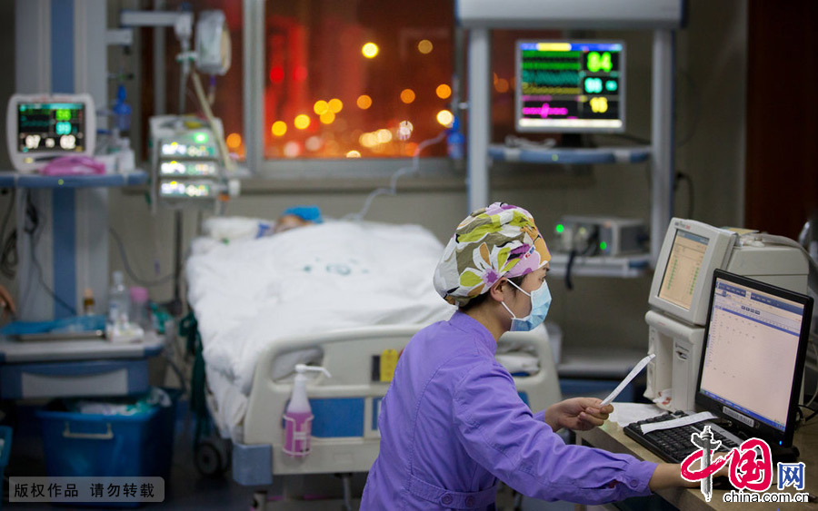  2015年2月7日，郑州，护士们不仅要确保病人的治疗状态正常，还要负责喂饭、安抚病人情绪、为病人做清洗工作，伺候病人大小便等生活护理，甚至要帮病人剪指甲，事无巨细。图为护士在认真的做护理记录。 图片来源：CFP