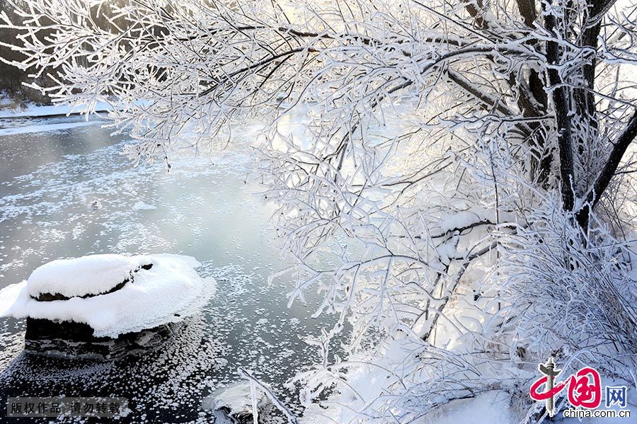  库尔滨水库的水电站每天发电都要释放摄氏零度以上的水，河水常年不冻，形成了浓浓的雾气。每年冬季，大量的雾气和冷空气融合交锋，便形成了壮观的仿若童话世界的雾凇奇景。中国网图片库 韩加君/摄