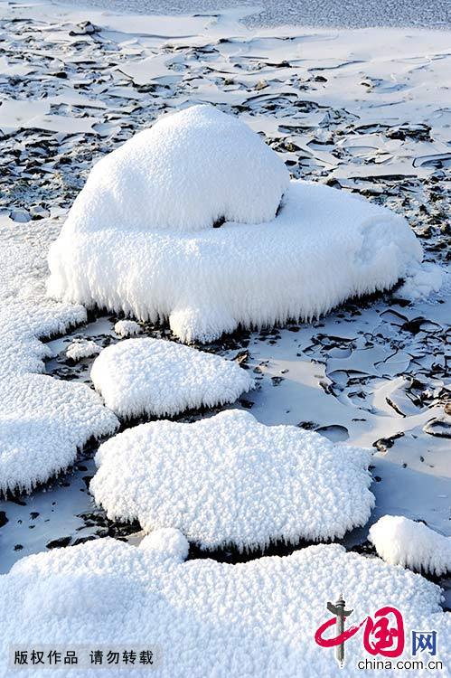  库尔滨水库的水电站每天发电都要释放摄氏零度以上的水，河水常年不冻，形成了浓浓的雾气。每年冬季，大量的雾气和冷空气融合交锋，便形成了壮观的仿若童话世界的雾凇奇景。中国网图片库 韩加君/摄