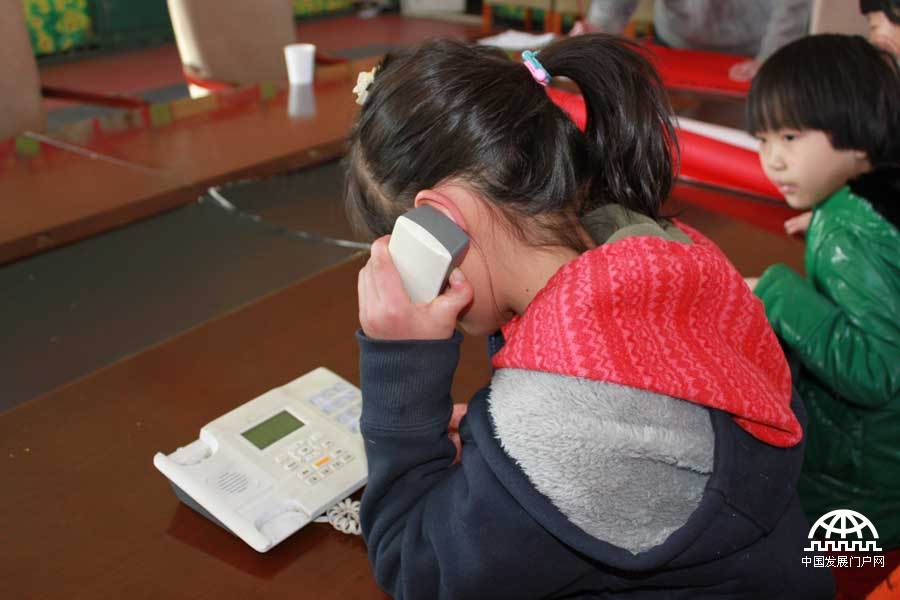 一个可爱的小女孩和正在服刑的父亲打电话，据太阳村负责人介绍，这个小女孩很有表演天赋，已经拍过两部电影了。中国网/中国发展门户网 魏博 拍摄