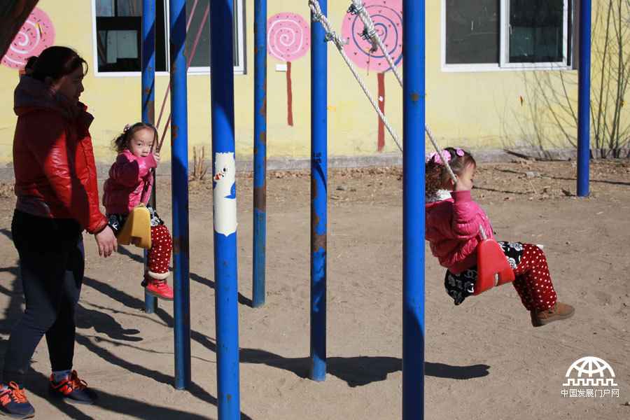  太阳村里，一对双胞胎小姐妹正在快乐地荡秋千。中国网/中国发展门户网 魏博 拍摄
