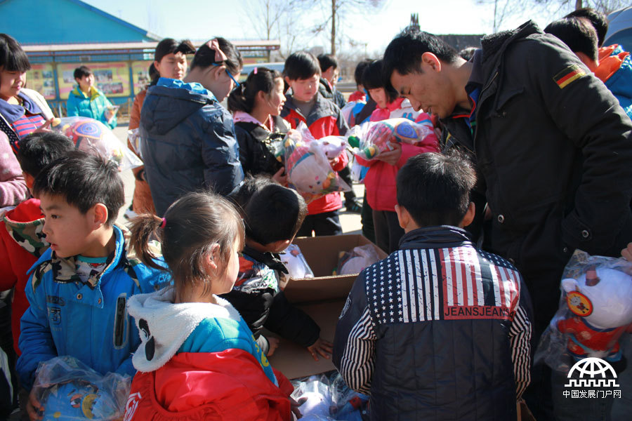  北京国是经纬科技有限公司的工作人员为孩子们发放动画片《新年娃娃》的动漫玩具，孩子们认真地挑选自己喜欢的玩具。中国网/中国发展门户网 魏博 拍摄
