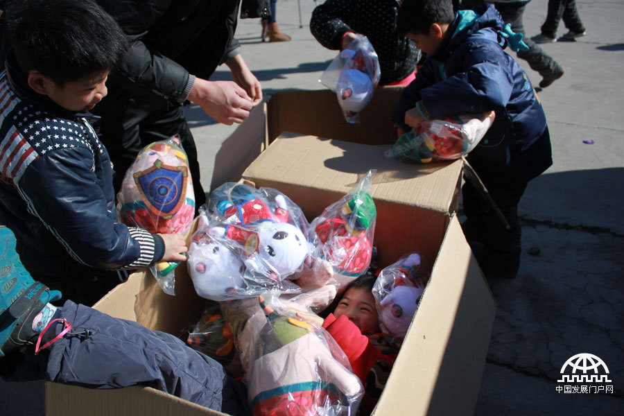 一个调皮的小男孩，钻进了装有玩具的大箱子。中国网/中国发展门户网 魏博 拍摄