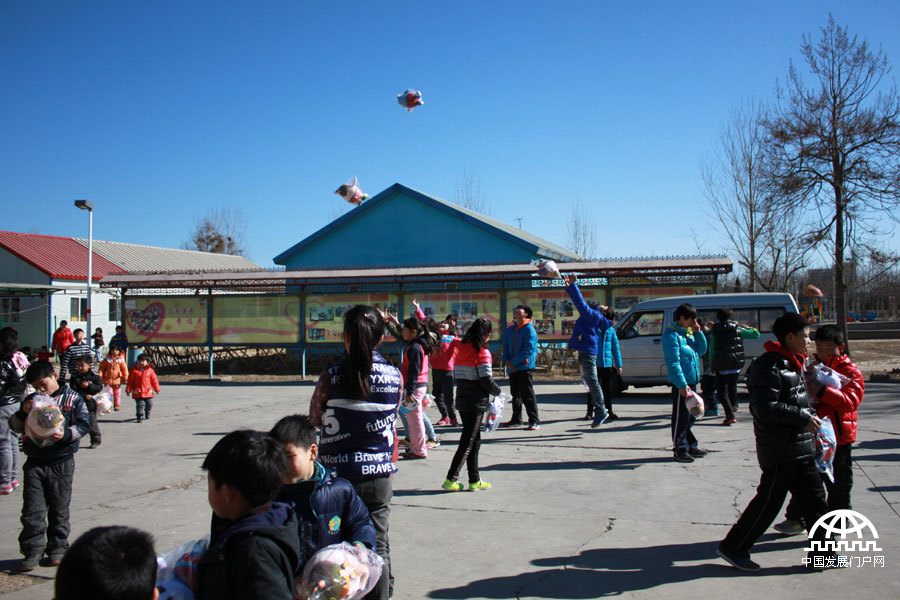  领到玩具的孩子们兴奋地将玩具抛到空中。中国网/中国发展门户网 魏博/摄