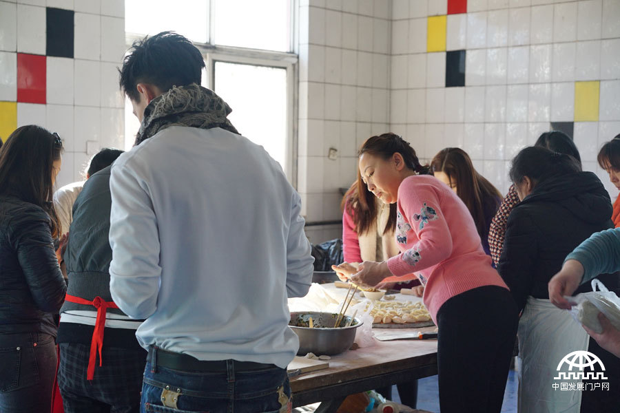 太阳村里的工作人员和志愿者们正在忙忙碌碌地包饺子。