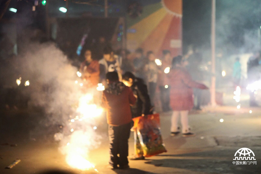 太阳村里热闹的篝火晚会，映着绚丽的烟花，孩子们灿烂的笑容非常美丽。