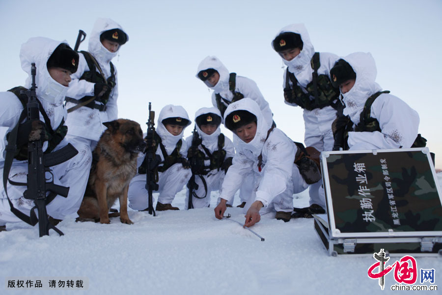 2013年12月28日，军犬“大宝”和黑河好八连巡逻组官兵冒着零下30度严寒气温正在对一可疑足迹进行检迹。