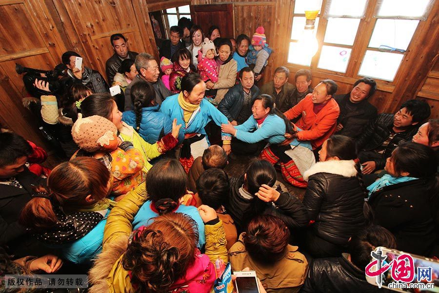  媒人公们围坐在火塘旁，女方家的姑娘则轮坐在媒人公的大腿上——“蹾屁股”， 这是花瑶人待客的最高礼仪。中国网图片库 曾勇/摄 