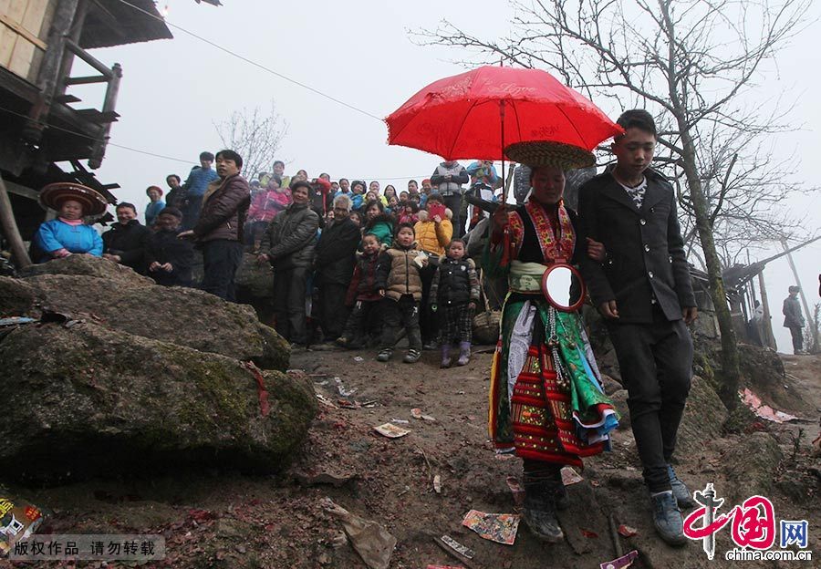 新娘被接出家门，寨子里的亲友都前来相送。中国网图片库 曾勇/摄