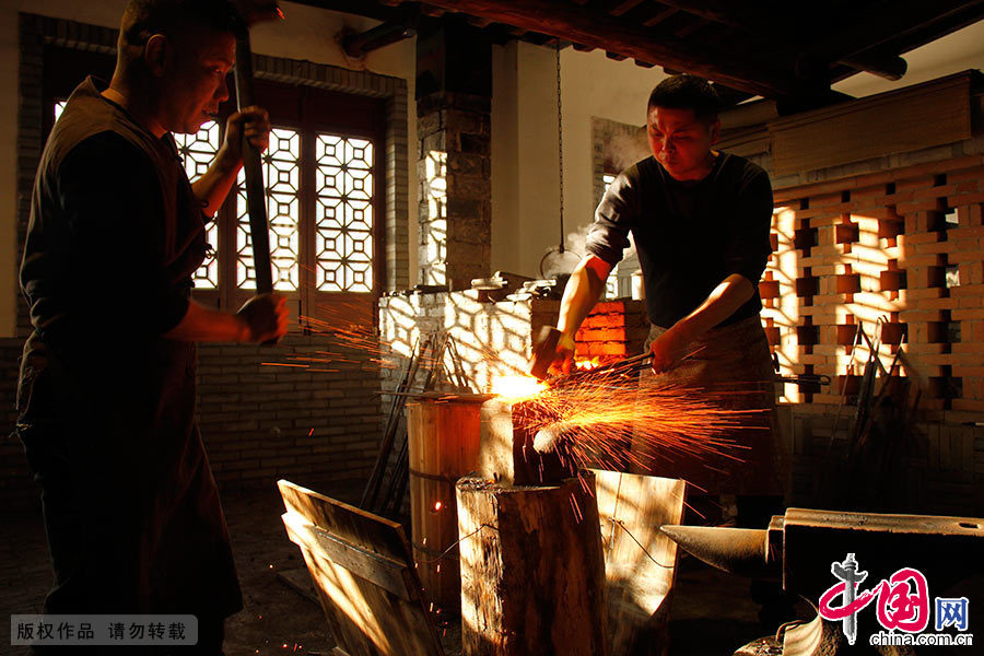  一把龙泉剑，从原料到成品，须经过打坯、热锻、铲、锉、镂花、嵌铜、磨光、装潢等28道工序。图为宝剑制作工艺之打坯。中国网图片库 吴春平/摄 