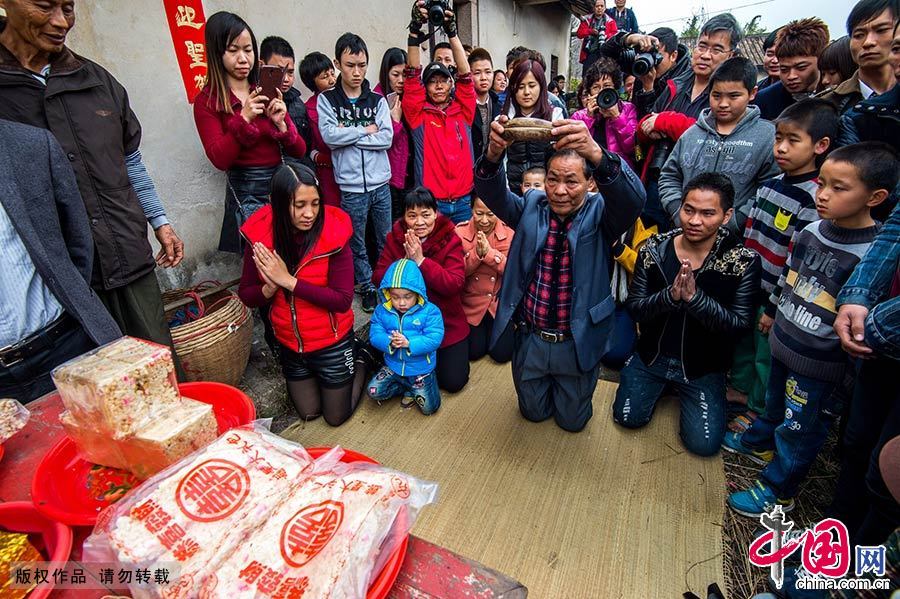 在每一个火墩之前，都要举行拜祭仪式，在村里的长者带领下，以卜卦的形式说出村民心中的祈愿并得到“老爷”的同意后，跳火墩方可正式开始。中国网图片库 邓飞/摄