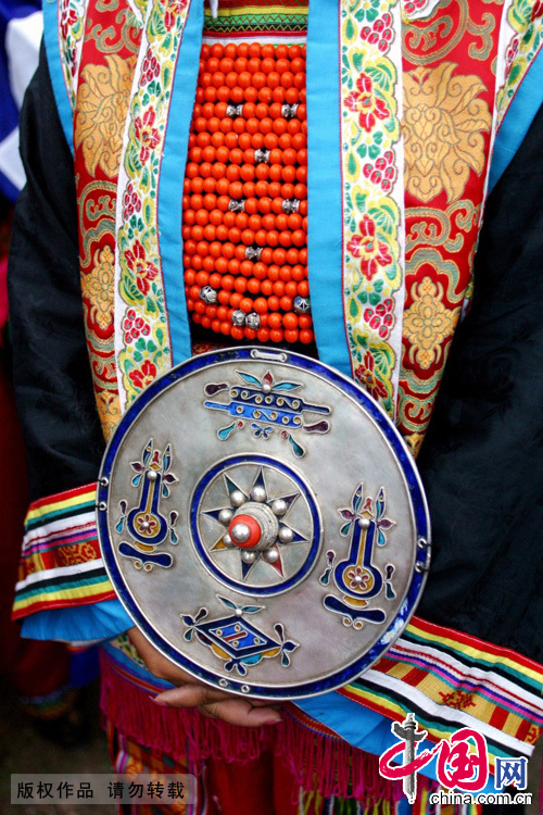 藏族妇女的胸饰“欧斗子”。“欧斗子”是藏族妇女的一种常见配饰，是一个直径为20-26厘米的圆形大银盘，藏语叫“欧斗子”。