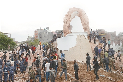 图为救援人员25日在加德满都的一处废墟上展开救援。 新华社发