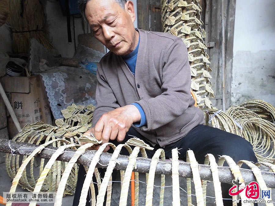 编扎湖口草龙的第三代传承人喻芳泽在龙骨架上安装龙片。中国网图片库 洪永林/摄