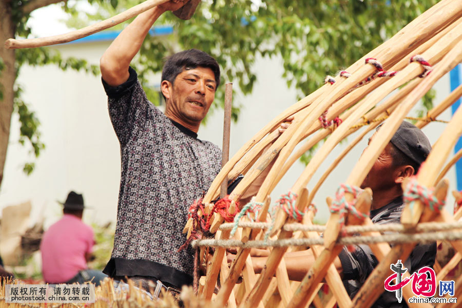 骨架搭好后，要在四个方向打入钢钉，防止毡房被风刮走。中国网图片库 孙继虎/摄