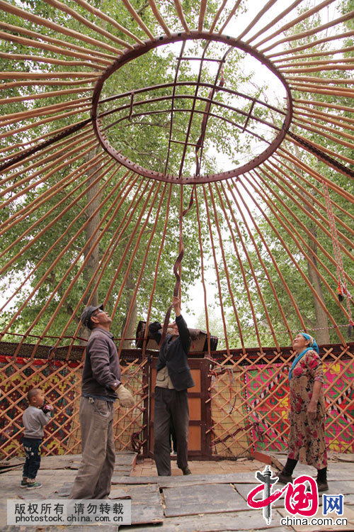 下层竹帘固定好后，就要挂第二层，上层毛毡需要两层，下面四张白毡，上层两张。中国网图片库 孙继虎/摄