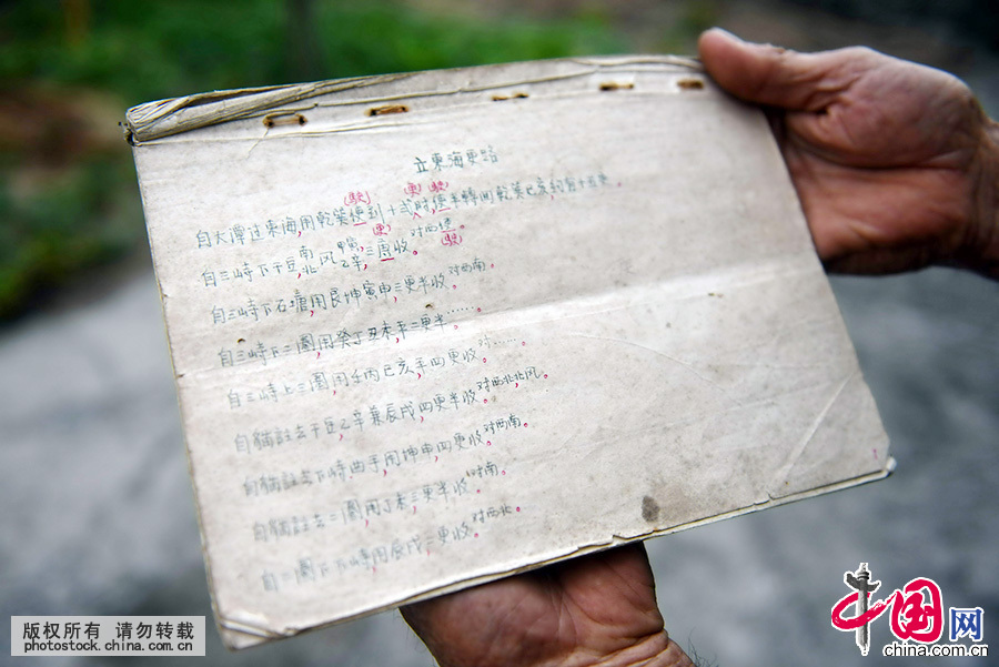 海南琼海市潭门镇，80高龄的老船长苏承芬展示爷爷手抄存留下来的《更路簿》。中国网图片库 蒙钟德 摄 