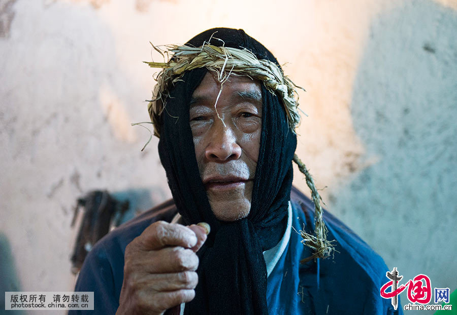  杨国顺，是会同高椅傩戏目前的传承人。演出前的化妆比较简单，不用涂脂抹粉，穿上服装，带上傩面具即可。杨国顺说：“不戴面具是人，戴上面具是神。”中国网图片库 尹忠 摄 