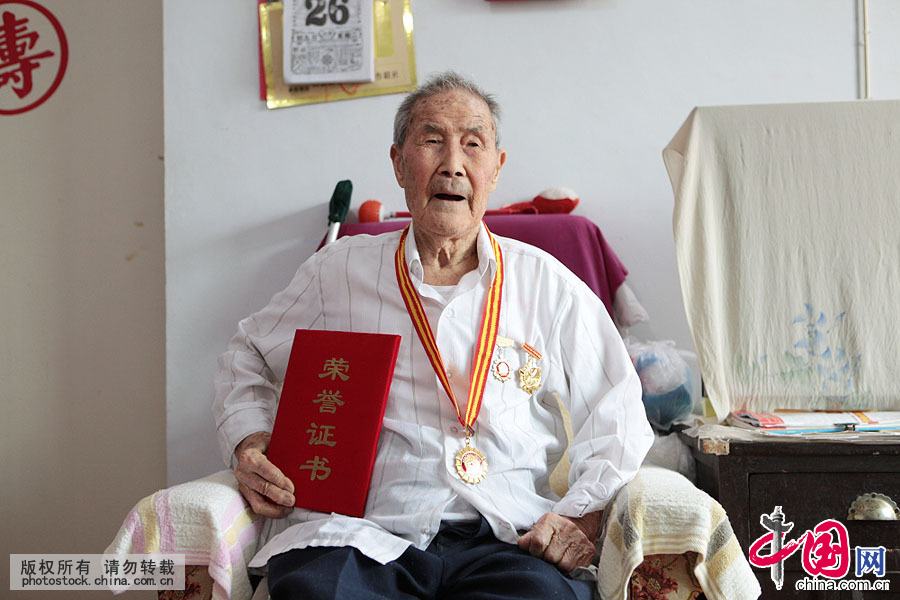 102岁的郭老70年前的身份是农村教师，实际上他已是一名中共地下党员。2005年中共中央、国务院、中央军委给郭宪同颁发有“纪念中国人民抗日战争胜利六十周年”纪念勋章一枚。中国网图片库 杨俊琦摄
