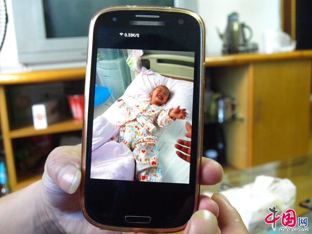 图为徐建华手机里存放着小雅婷在上海进行基因移植前的照片。 中国网图片库