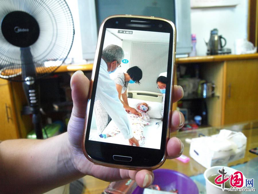 图为徐建华手机里存放着小雅婷在上海进行基因移植前的照片。中国网图片库