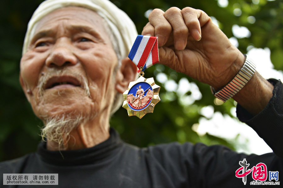 曾庆平向我们展示他的抗日英雄纪念章。中国网图片库 罗星汉摄