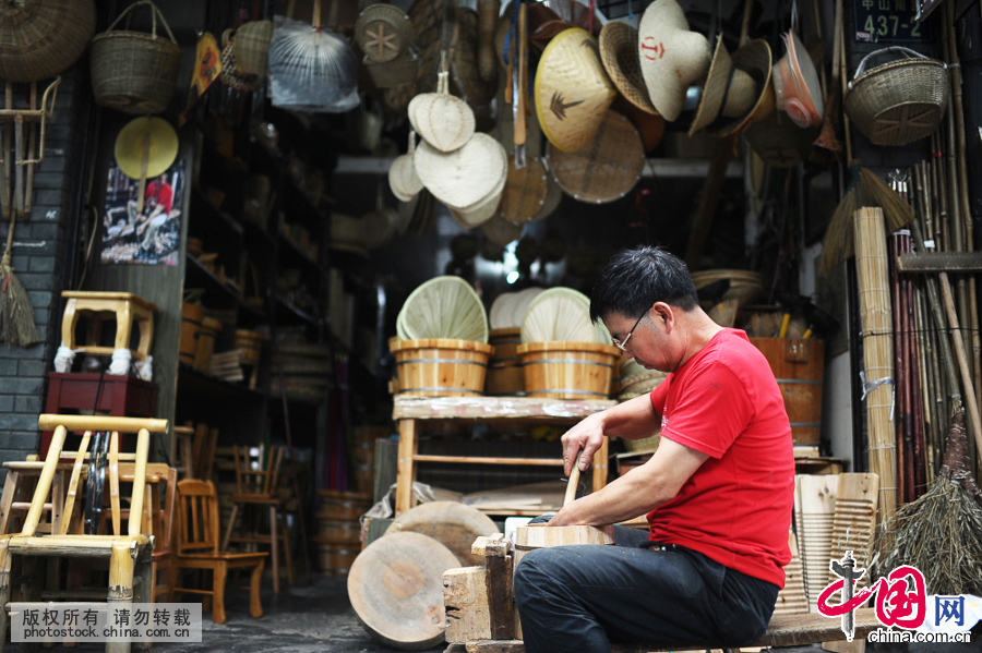  中山南路南宋御街一带，来往不息的人群和车流，带着这个城市的繁华和喧闹。而就在这个烟酒食肆林立的地方，63岁的戚建飞，拿起木刨，在自家门前做起木工活来。中国网图片库 王川摄