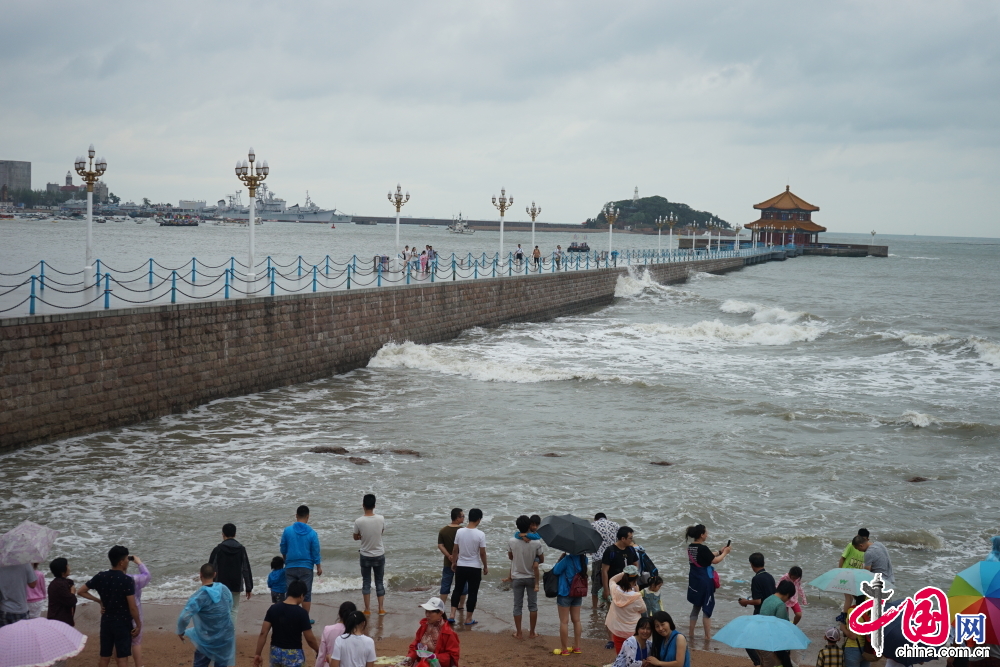  7月12日，山东青岛，第9号台风“灿鸿”全面影响青岛。沿海景区看到，受到台风影响，几米高的海浪不断击打岸边。栈桥及青岛各大海水浴场拉起游客警示牌，暂停开放。