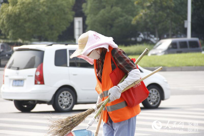 烈日下，合肥一位环卫工人在路上清扫垃圾。李彬 摄