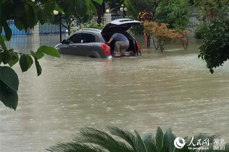 7月23日，武汉再遭暴雨袭击，汉口一小区外，一辆新车被淹。人民网 李如胜 摄