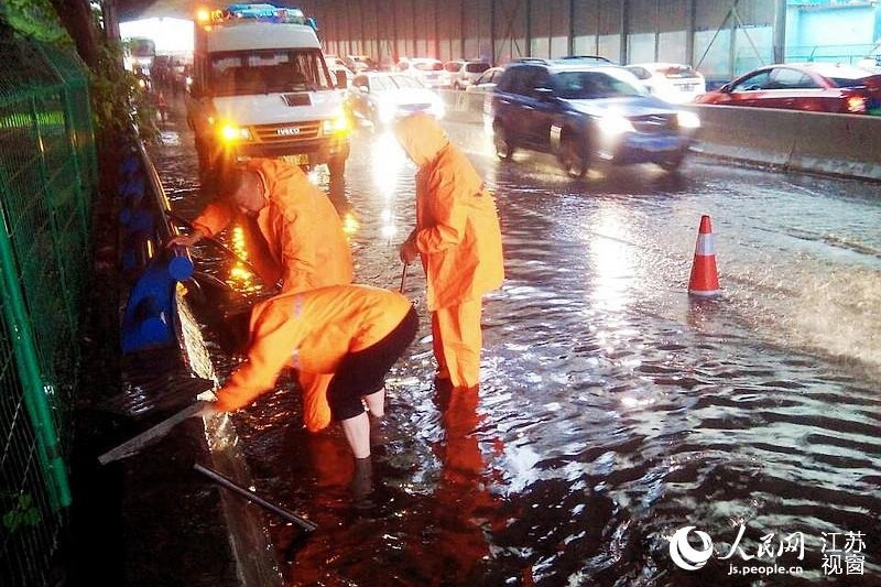 南京市政部门在城河路高架人工助排。人民网 姚媛 摄