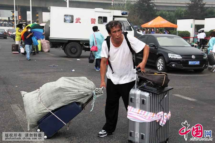 8月18日上午，在位于爆炸核心区周边的清水蓝湾小区居民继续返回家中取物，期间突遇降雨，武警天津市滨海新区支队官兵紧急护送居民撤离小区。中国网图片库 王胜涛摄