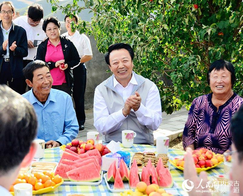 自治区党委书记王君在巴林左旗半拉沟村村民郑正泽家与当地村民详谈“十个全覆盖”给村里带来的大变化。