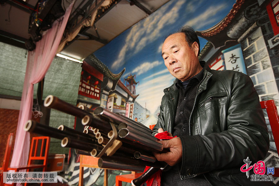 11月9日，安徽省蒙城县三义镇岗河村，每场演出结束时，朱洪敏都要逐个检查一下乐队伴奏的乐器。中国网图片库 胡卫国 摄