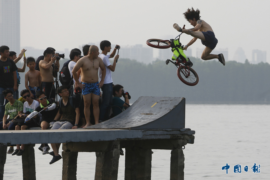 2015年7月18日，湖北武汉，运动爱好者围观“2015BMX跳东湖”比赛。BMX 为自行车越野的英文简称，是一项上世纪70年代中后期兴起并风靡于美国的时尚运动。 中国日报亚洲新闻图片网 李鹏 摄影