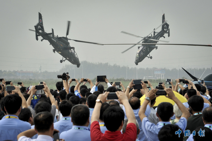 2015年9月9日，第三届中国天津国际直升机博览会上，观众观看拍摄两架直-19直升机进行低空飞行表演。 中国日报亚洲新闻图片网 王欢 摄影