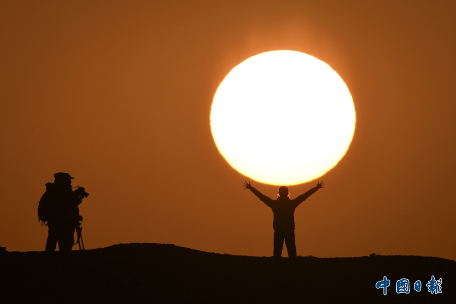 2015年10月3日，新疆维吾尔自治区巴音郭楞蒙古自治州，游客在达林达板景区观赏日出美景。中国日报亚洲新闻图片网 确·胡热 摄影